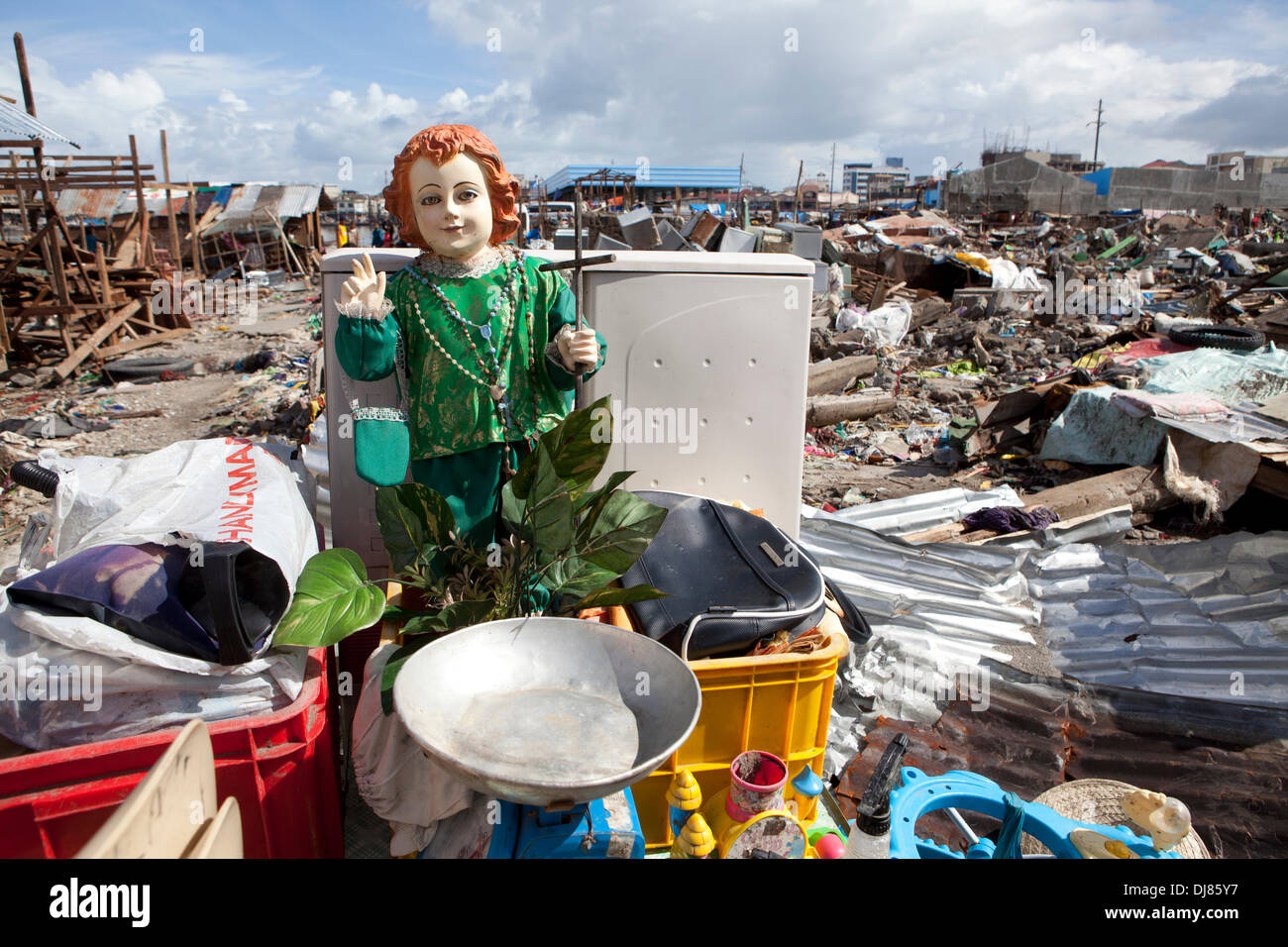 Approxametly 75% of local residents near to the Port area of Tacloban were evacuated.The extreme power of the storm surge accompanying Typhoon Haiyan/Yolanda devastated buildings in its path both wooden and concrete.the Santo Nino figurine salavaged in this image bares testament to the strong Catholic faith within Filipino communities. Stock Photo
