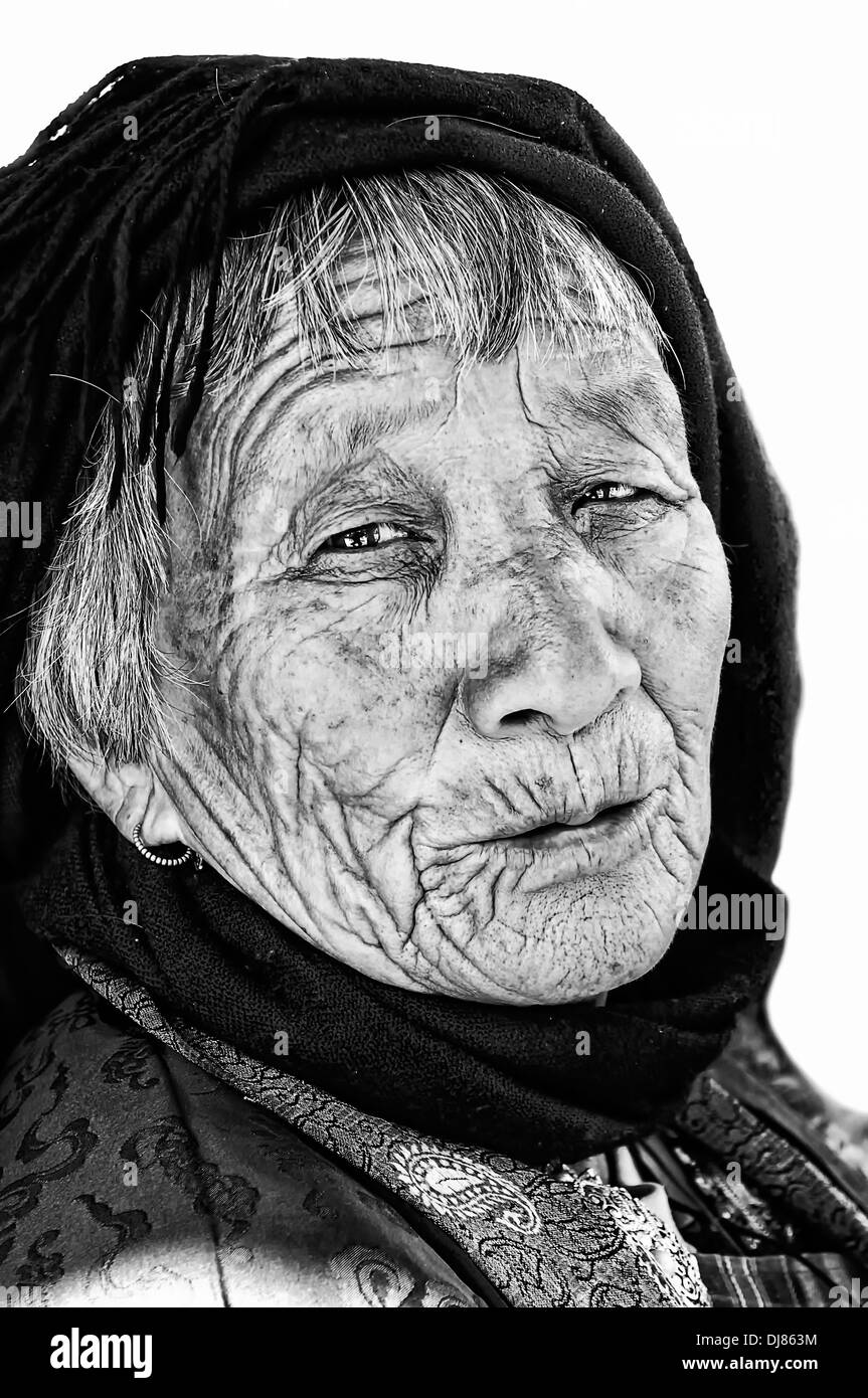 Bhutanese Old Lady in prayer dress isolated on white in black and white with copy space Stock Photo