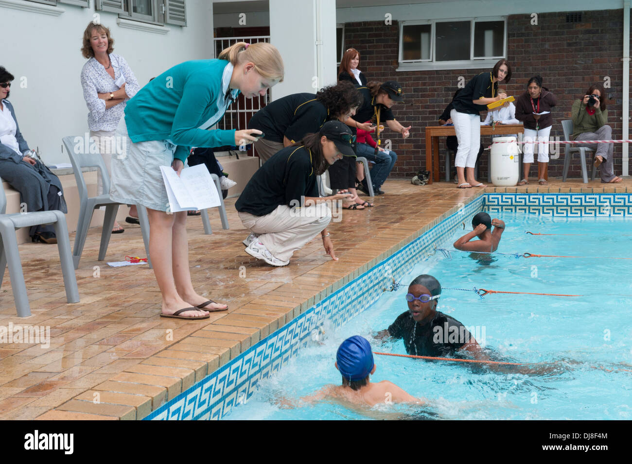 Teachers timing results at swimming gala at St. George's School, Cape Town, South Africa Stock Photo