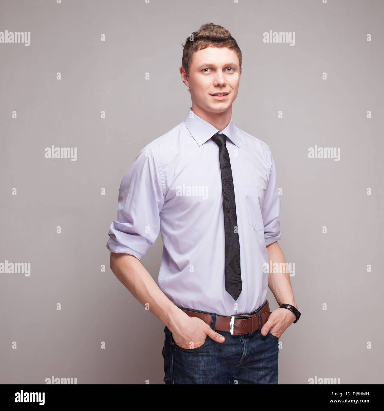 square portrait of cheerful young man in blue shirt with tie and jeans Stock Photo