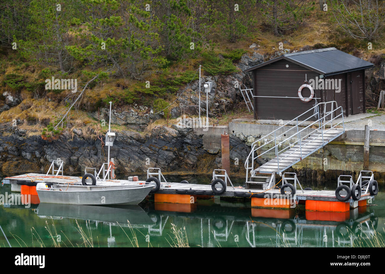 Small floating pier with moored motorboat in Norway Stock Photo
