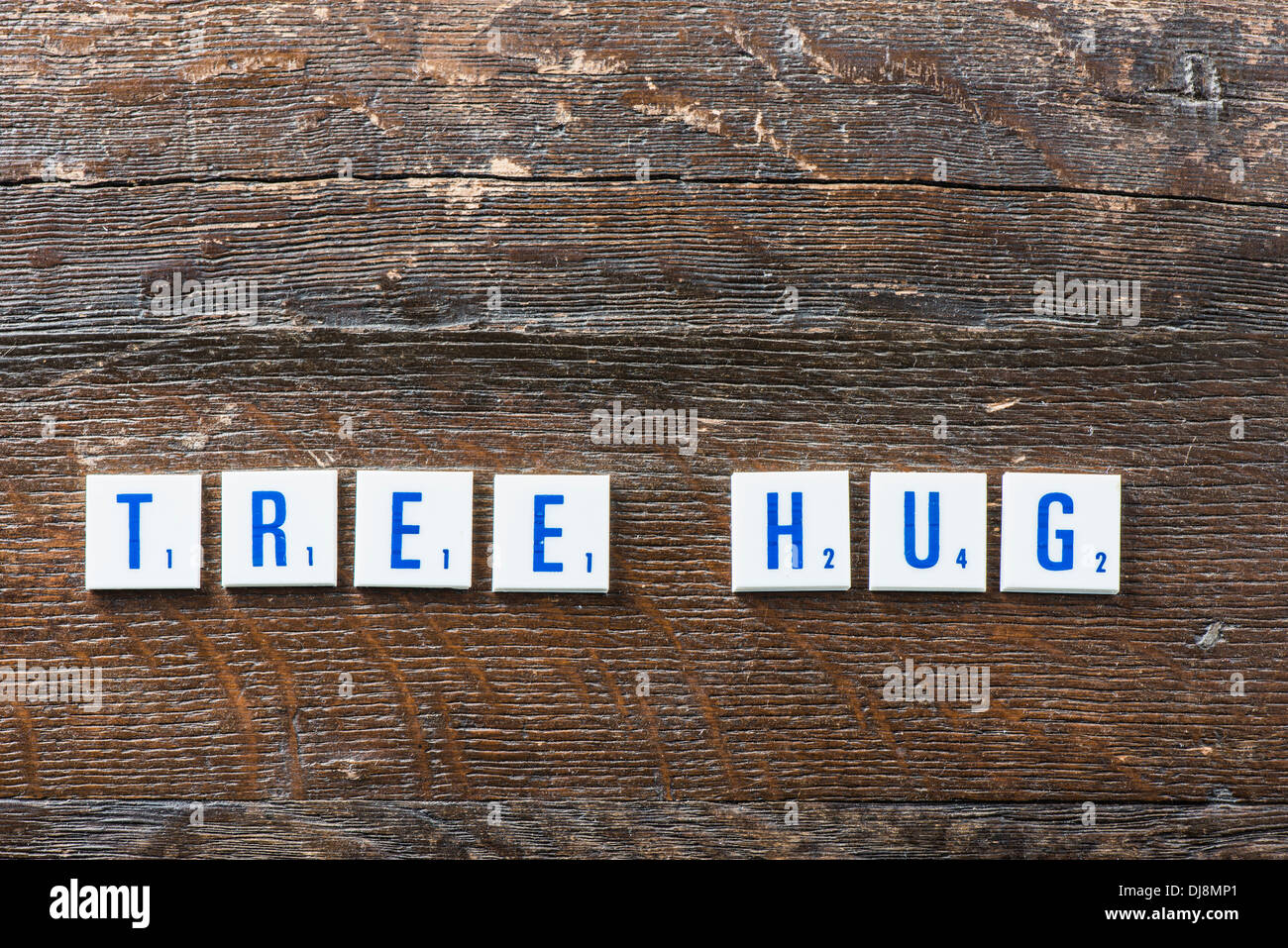 Letters lying on wood spelling the words Tree Hug Stock Photo
