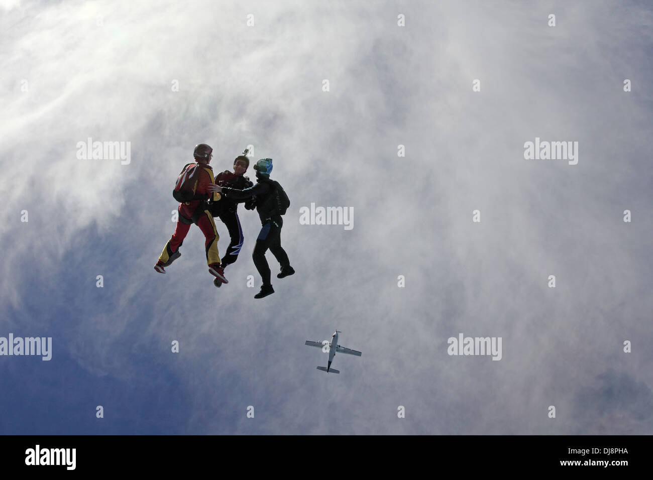 This freefly skydiving team jumped out of an aircraft and is holding hands together. It is fun for all to fly free in the sky. Stock Photo