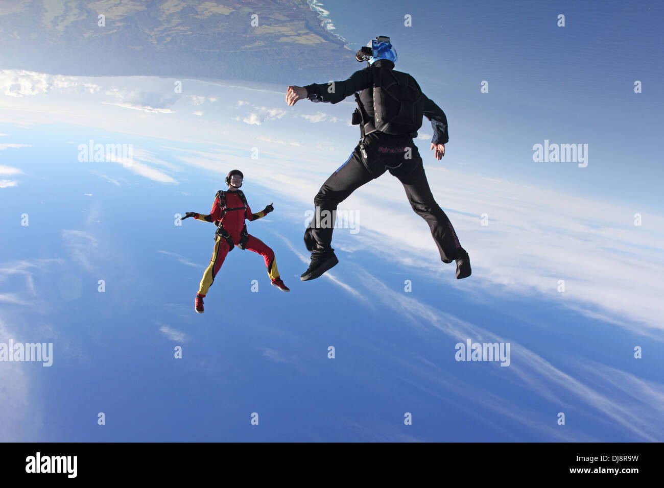 These freefly skydivers are flying head over with high speed (over 135 MPH). They have fun playing together in the blue sky. Stock Photo