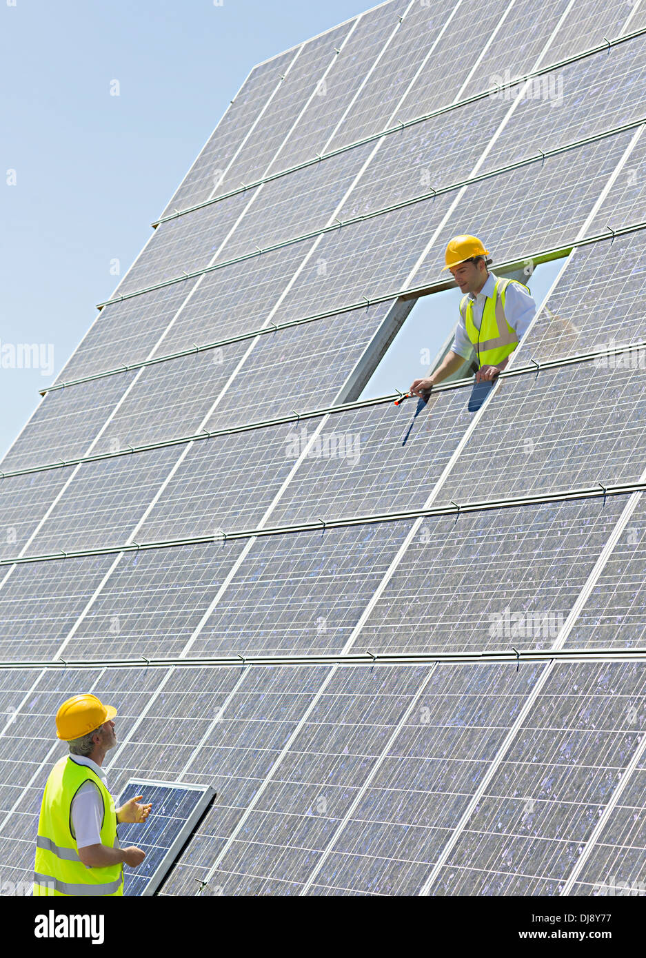 Workers examining solar panels Stock Photo