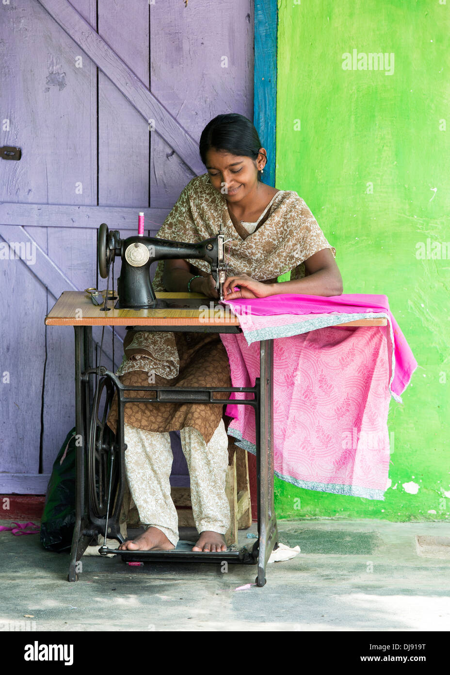 Teenage Indian girl on a sewing machine making clothes in a rural indian village. Andhra Pradesh, India Stock Photo