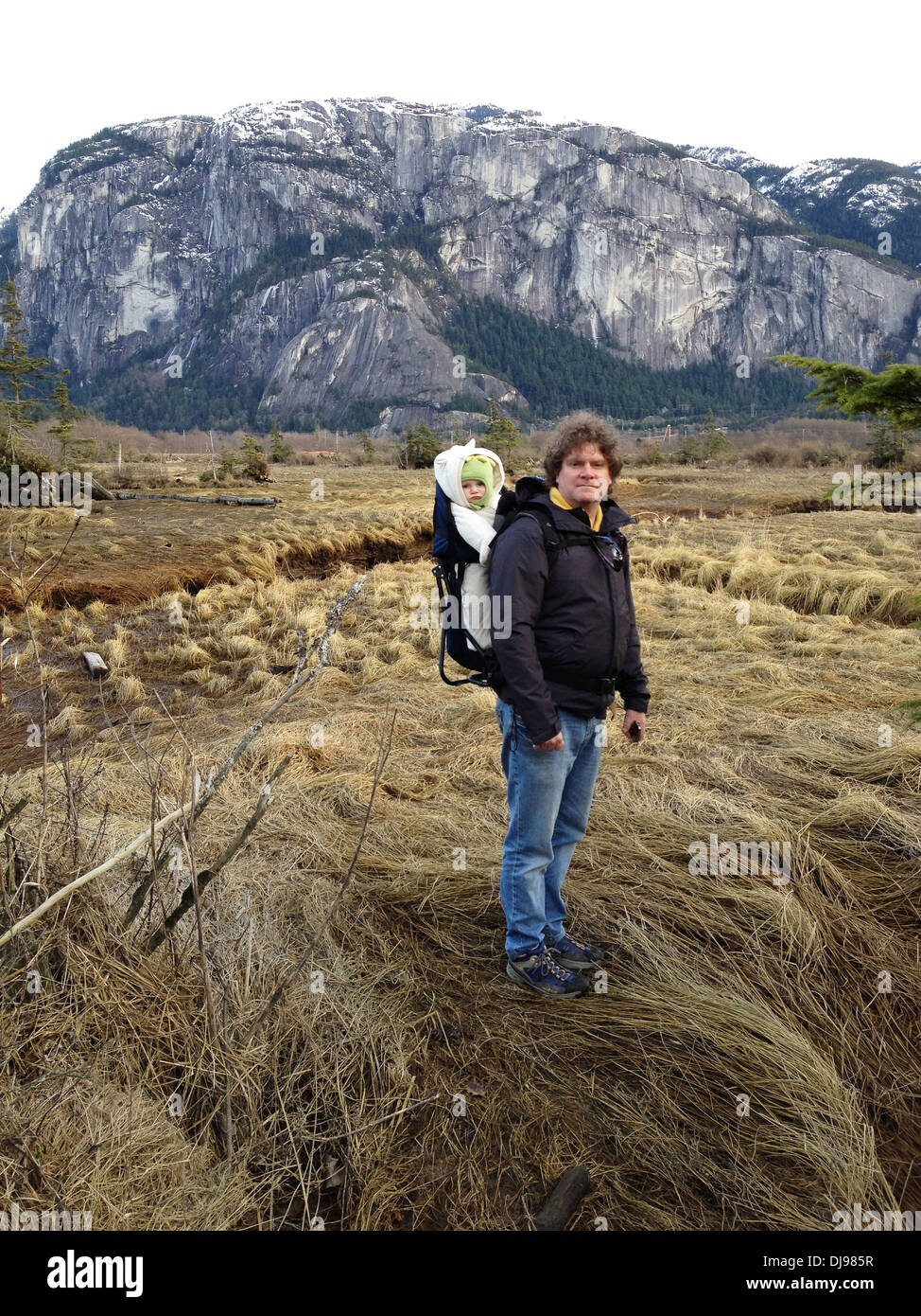 Caucasian man carrying baby in valley - Smartphone Captured Stock Image