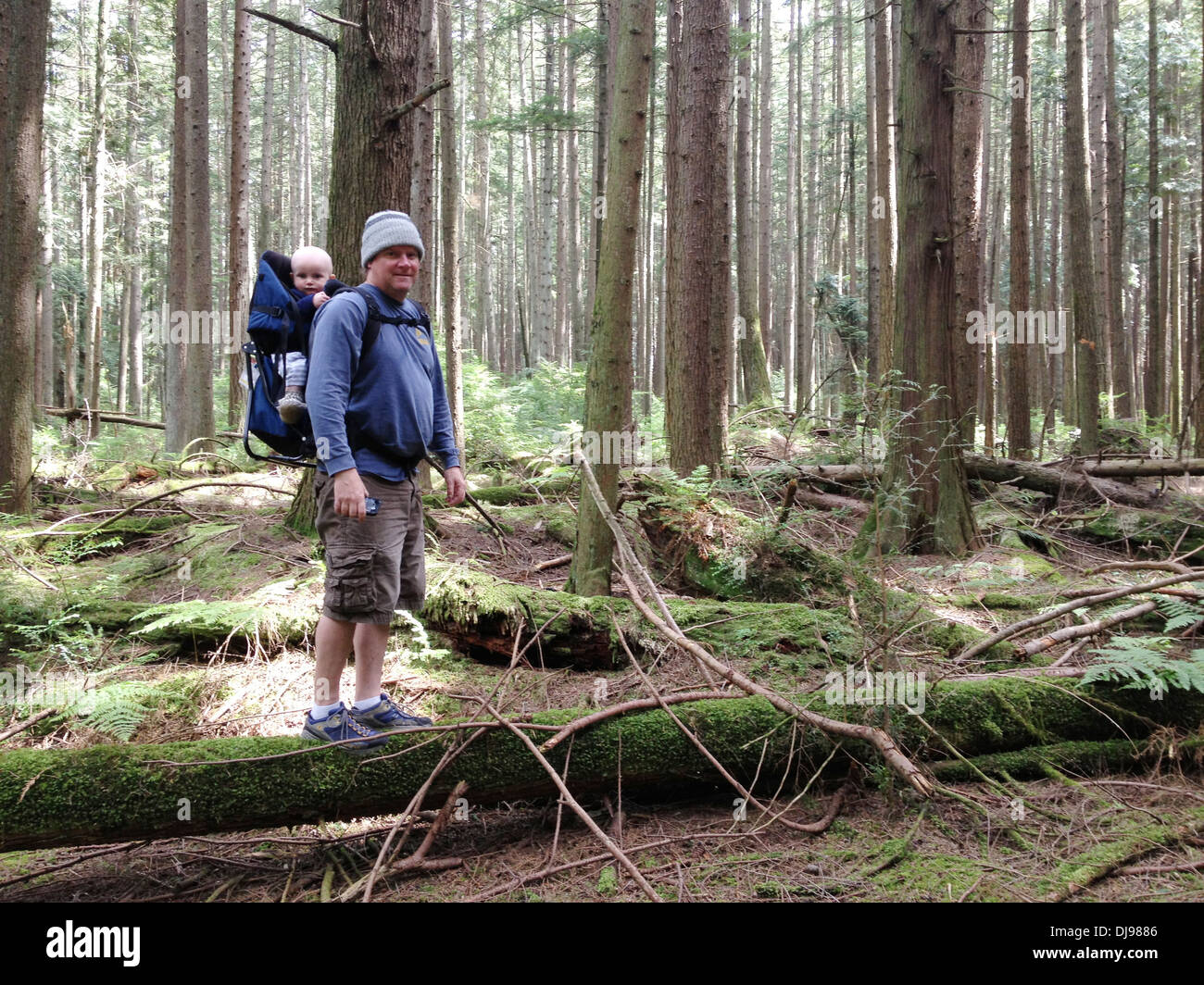Caucasian father carrying baby in forest - Smartphone Captured Stock Image