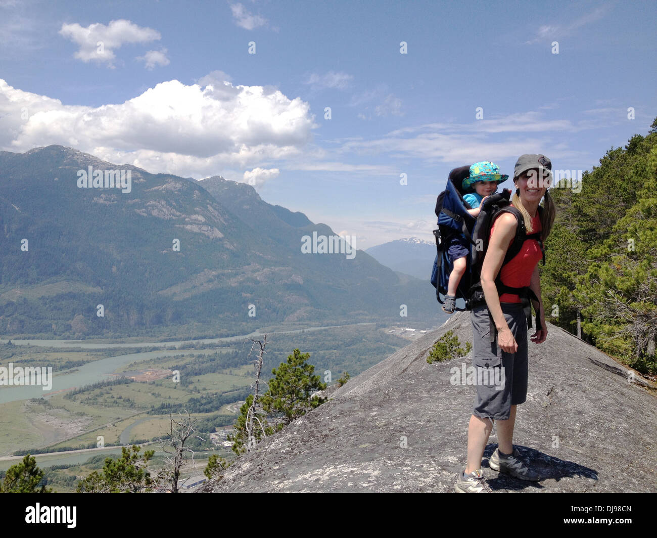 Caucasian mother carrying baby in rural landscape - Smartphone Captured Stock Image