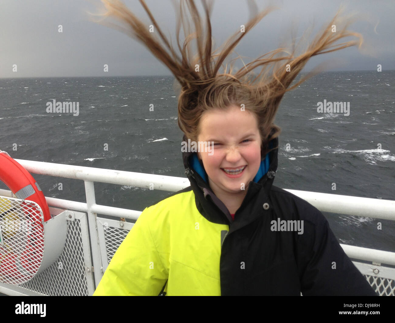 Caucasian girl's hair blowing in wind on boat Stock Photo