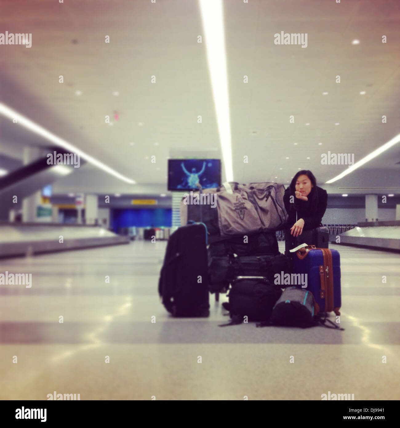 Woman with luggage waiting in airport - Smartphone Captured Stock Image
