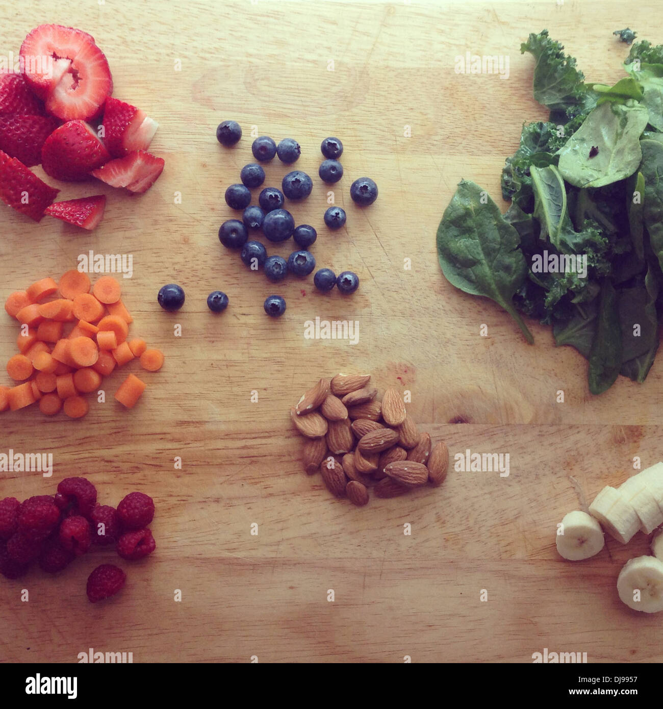 Piles of fruit, nuts and greens on wooden board - Smartphone Captured Stock Image