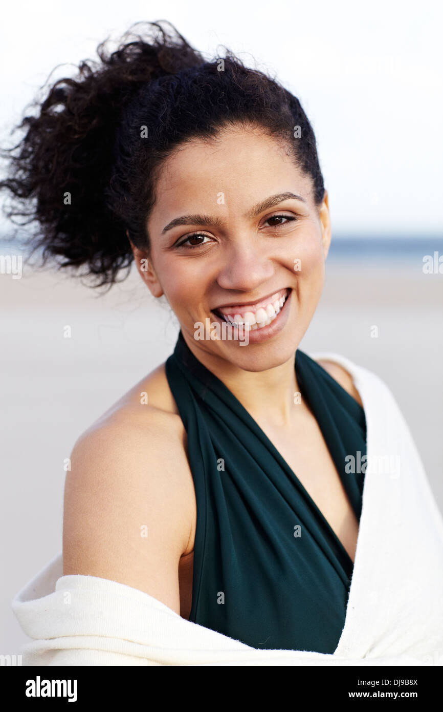 Mixed race woman smiling on beach Stock Photo
