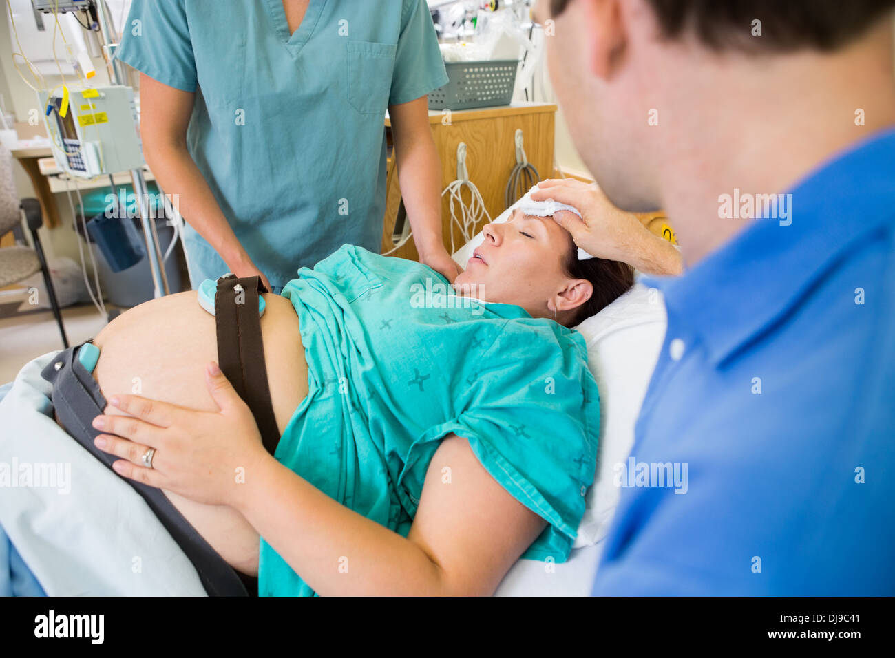 Loving Husband Wiping Pregnant Wife's Forehead Stock Photo
