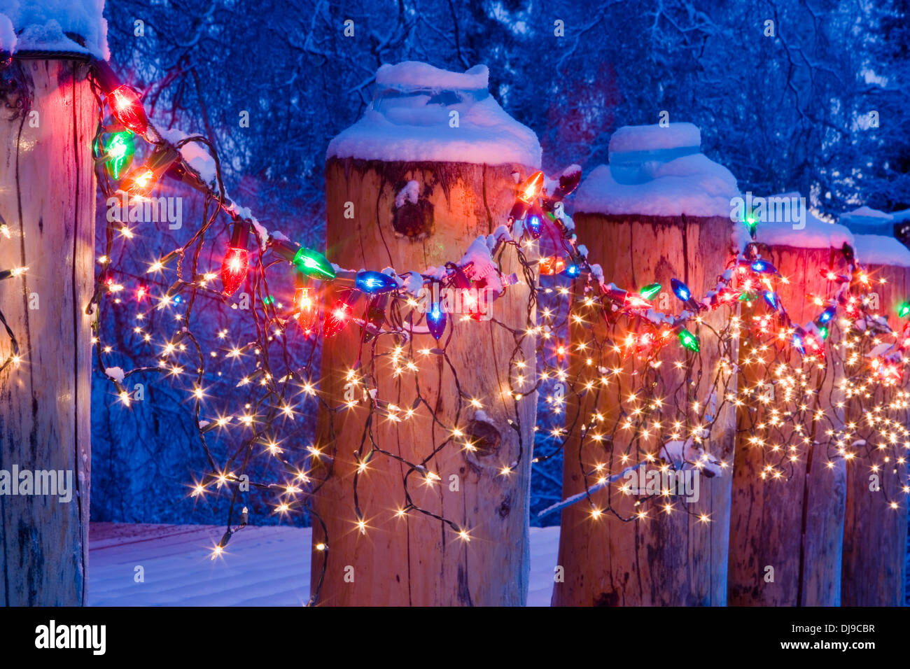 Close Up Of Christmas Lights On Log Cabin Porch Railing At Twilight