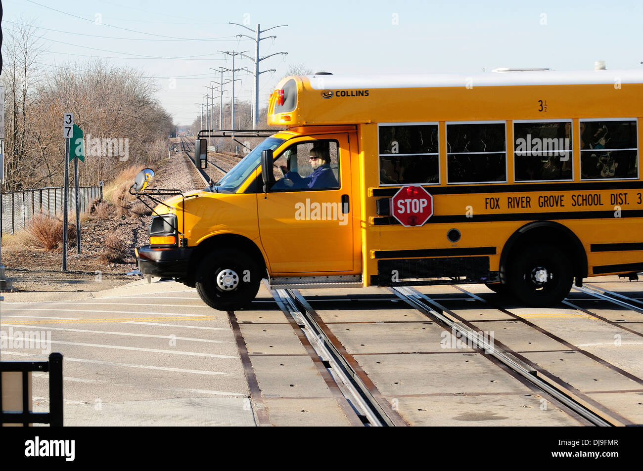 School bus driving across train tracks Stock Photo Alamy