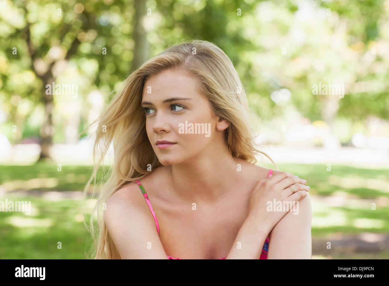 Serious young woman relaxing on a lawn Stock Photo - Alamy