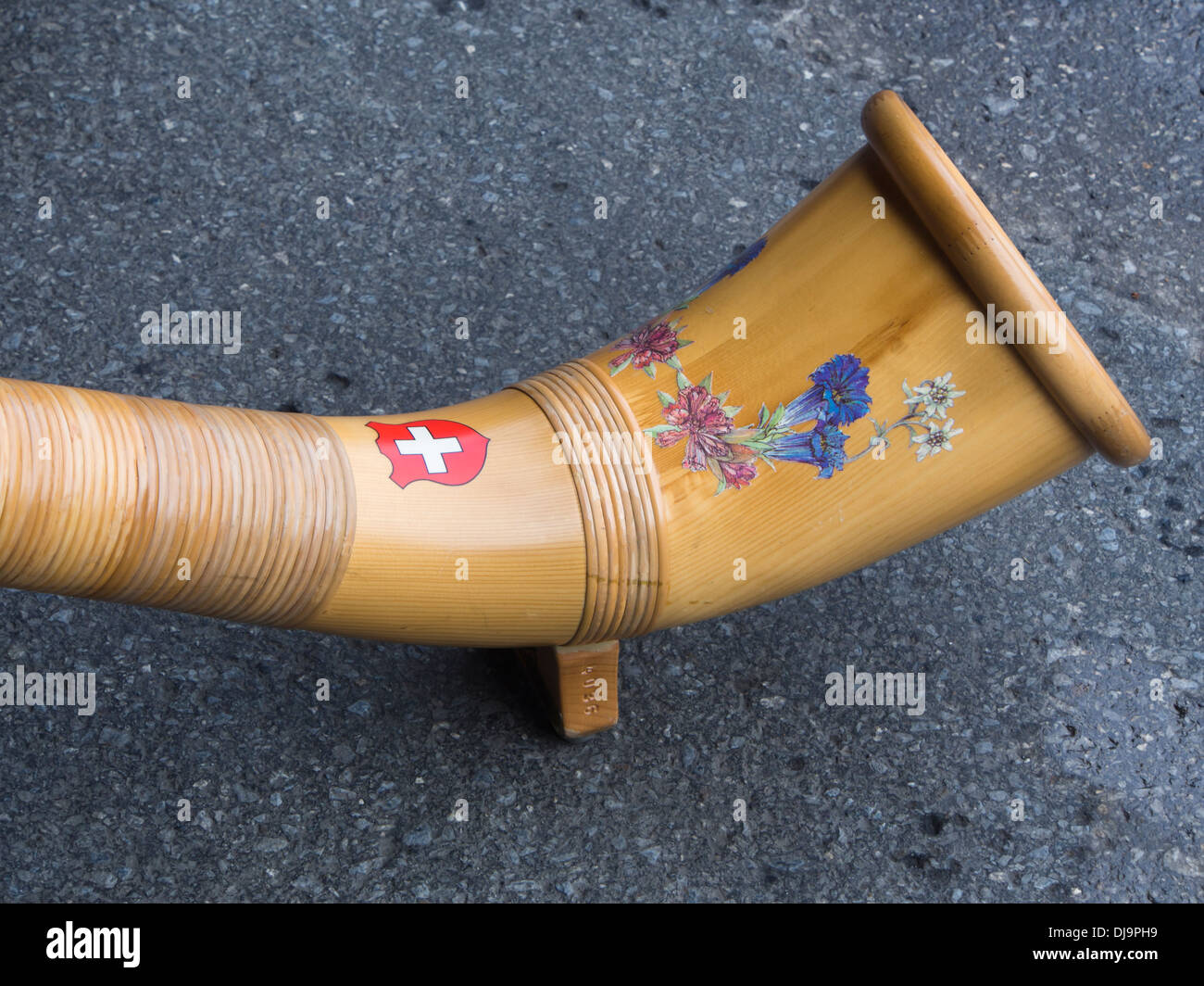 Closeup of part of an alphorn with Swiss wepon and flower decoration Stock Photo