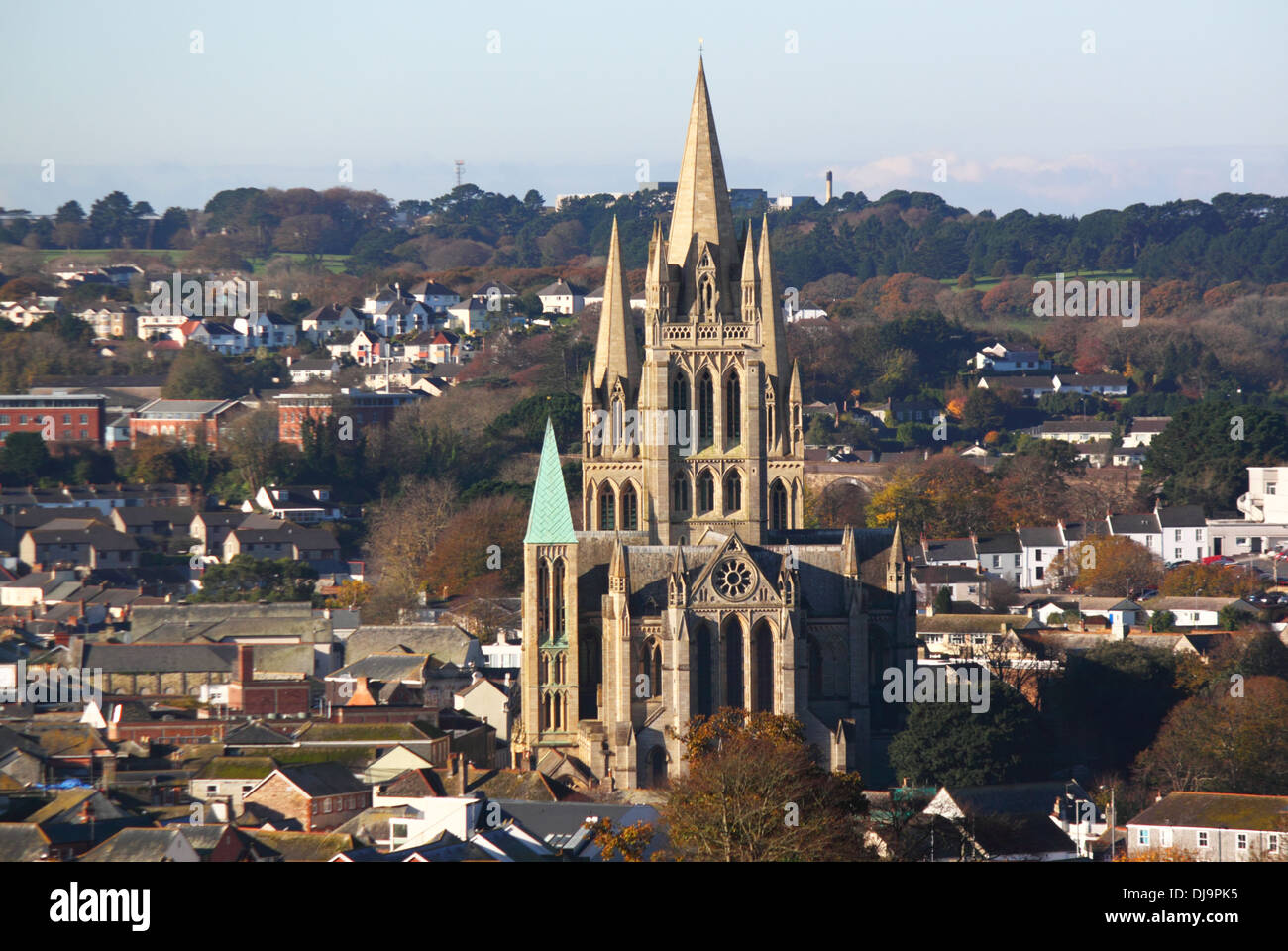 A gothic-style cathedral with a copper spire surrounded by buildings. Stock Photo