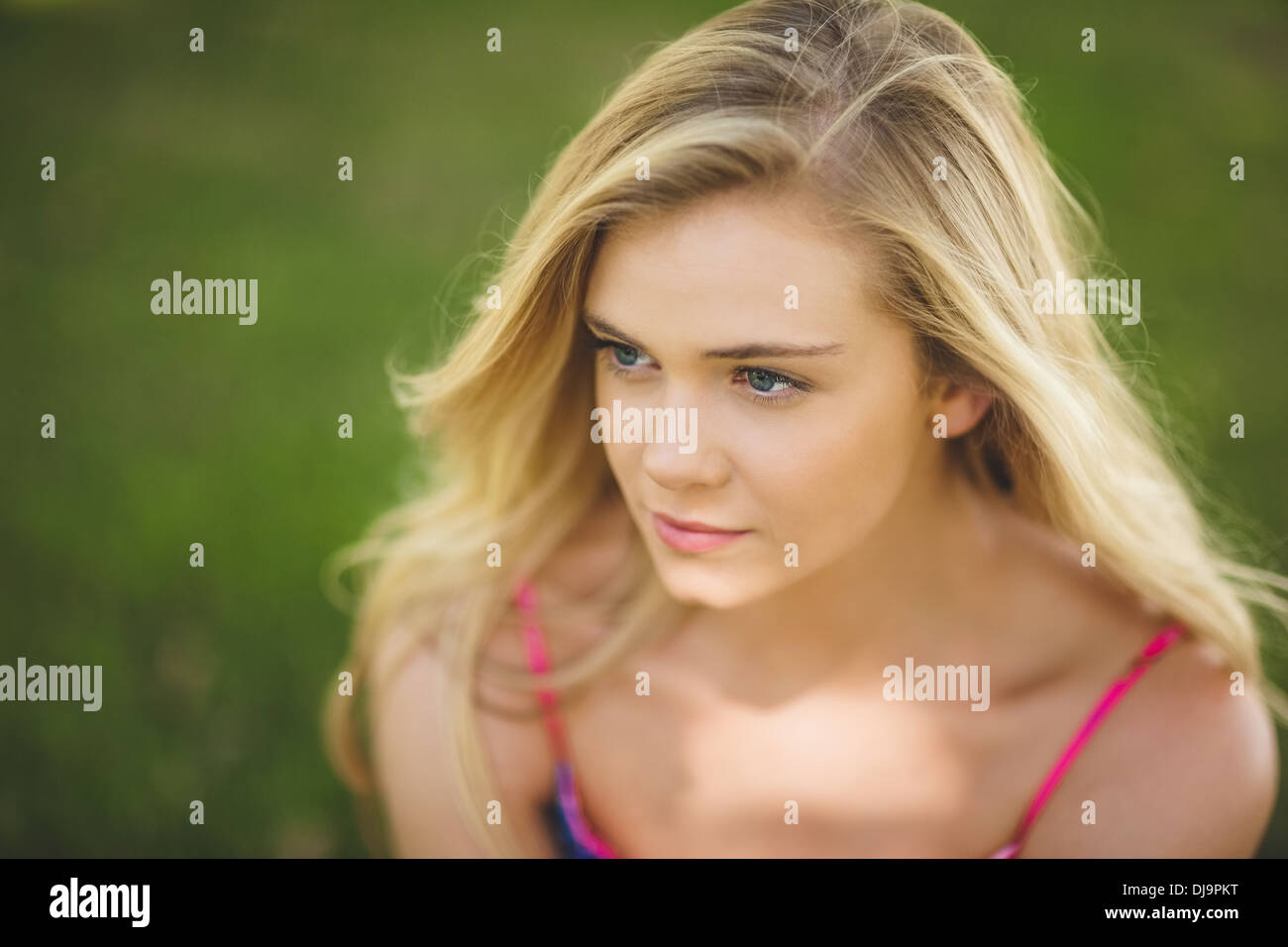 Thoughtful young woman relaxing on a lawn Stock Photo - Alamy