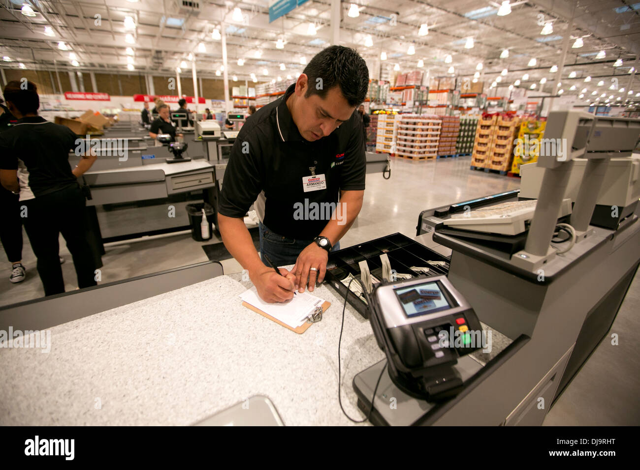 COSTCO warehouse employee counts cash money in his register before beginning shift at new store in Texas Stock Photo