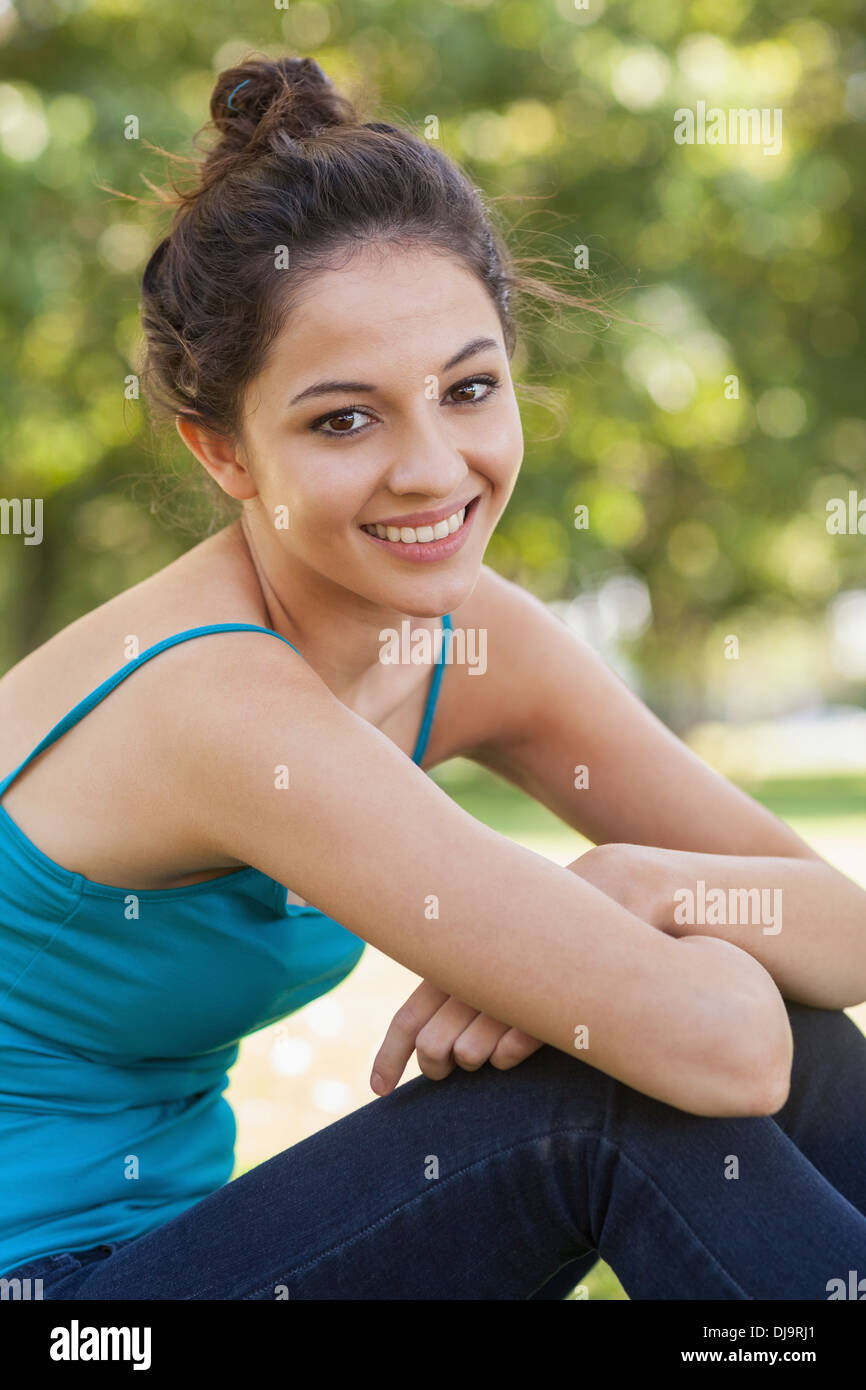 Beautiful young woman sitting on a lawn Stock Photo - Alamy