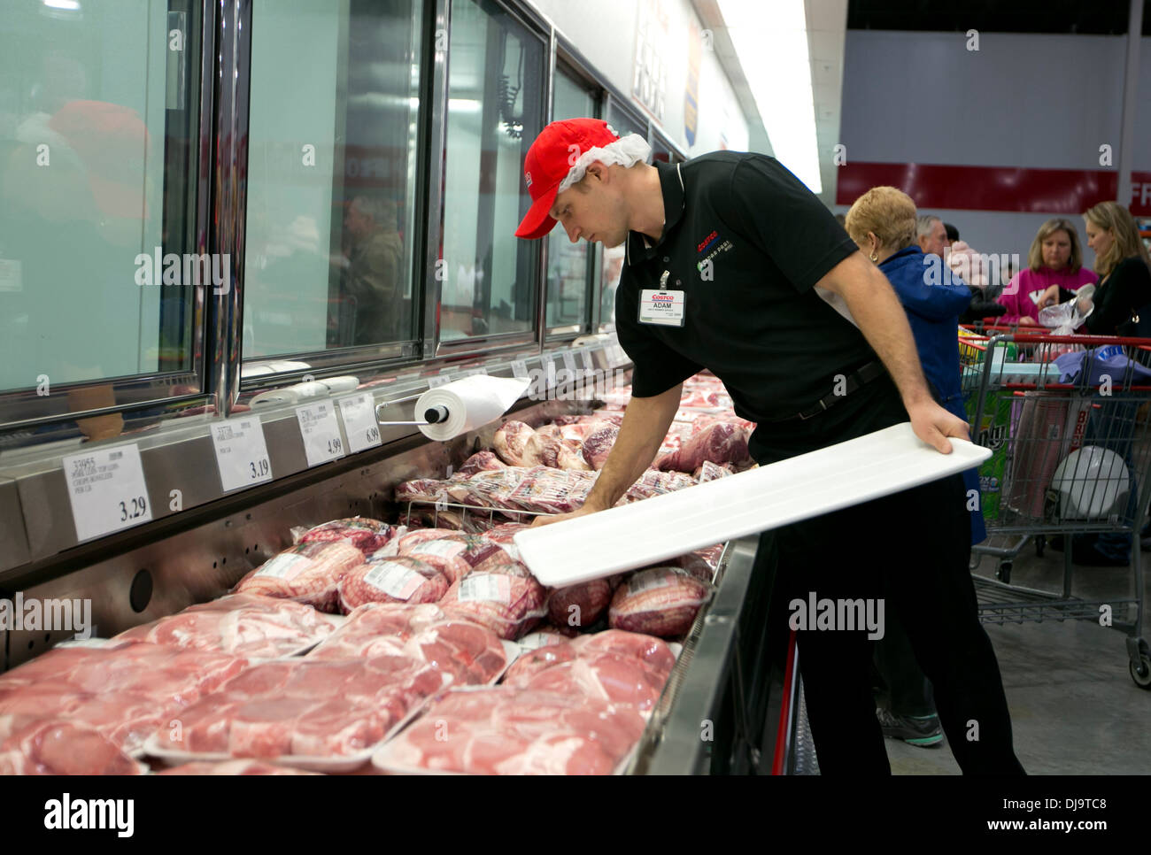 Employee stocks fresh packaged meat at at newly open COSTCO warehouse retail store in Cedar Park