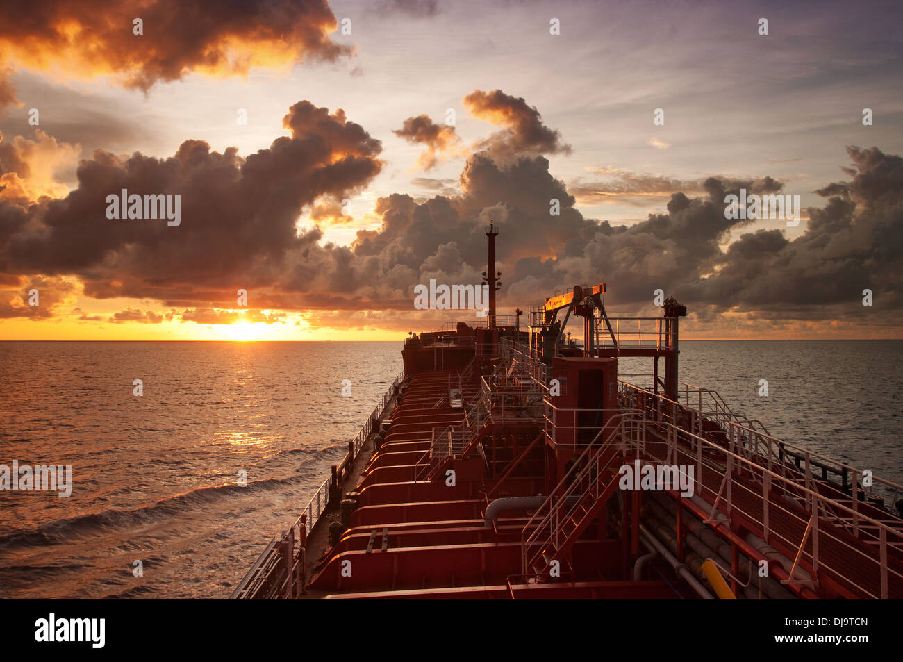 oil tanker at open sea during sunset with beautiful  sky and cloud during sunset Stock Photo