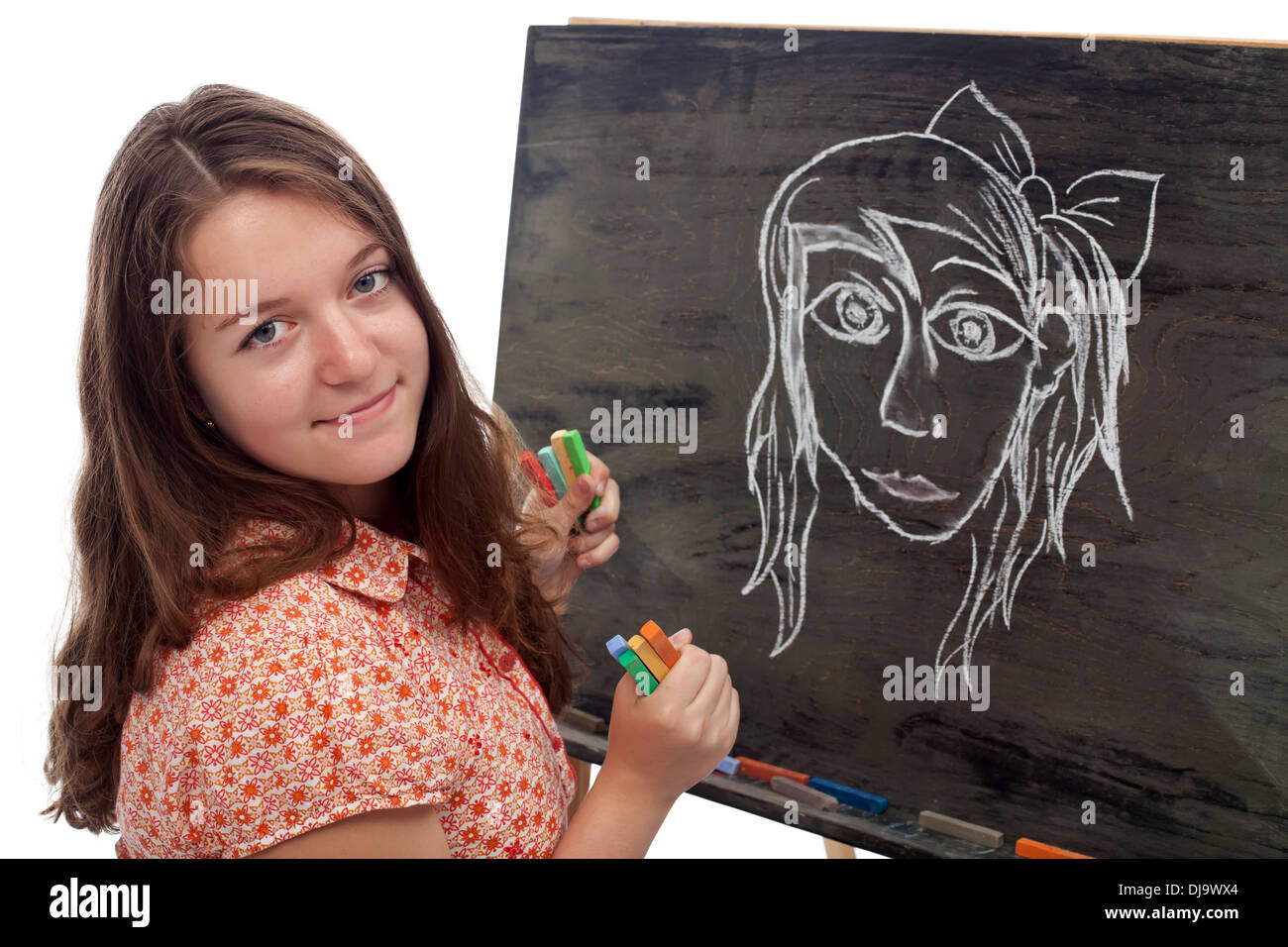 Young artist student drawing on black board with colored chalk Stock Photo