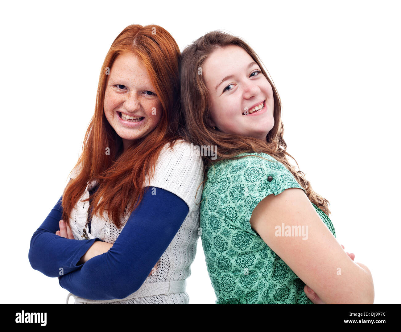 Happy teeng girls standing back to back and smiling Stock Photo