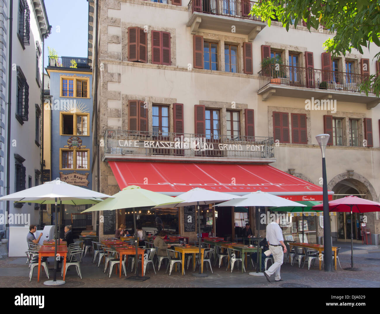 Pedestrian street, café, brasserie with outdoors seating and houses, relaxed lifestyle in the Swiss town of Sion Stock Photo
