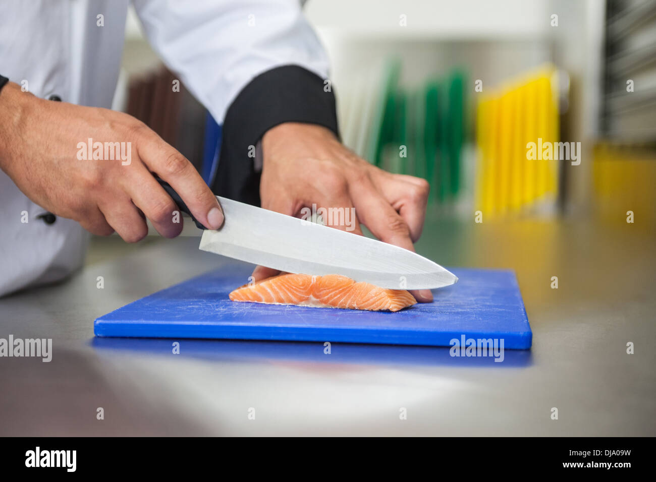 https://c8.alamy.com/comp/DJA09W/chef-slicing-raw-salmon-with-knife-on-blue-cutting-board-DJA09W.jpg