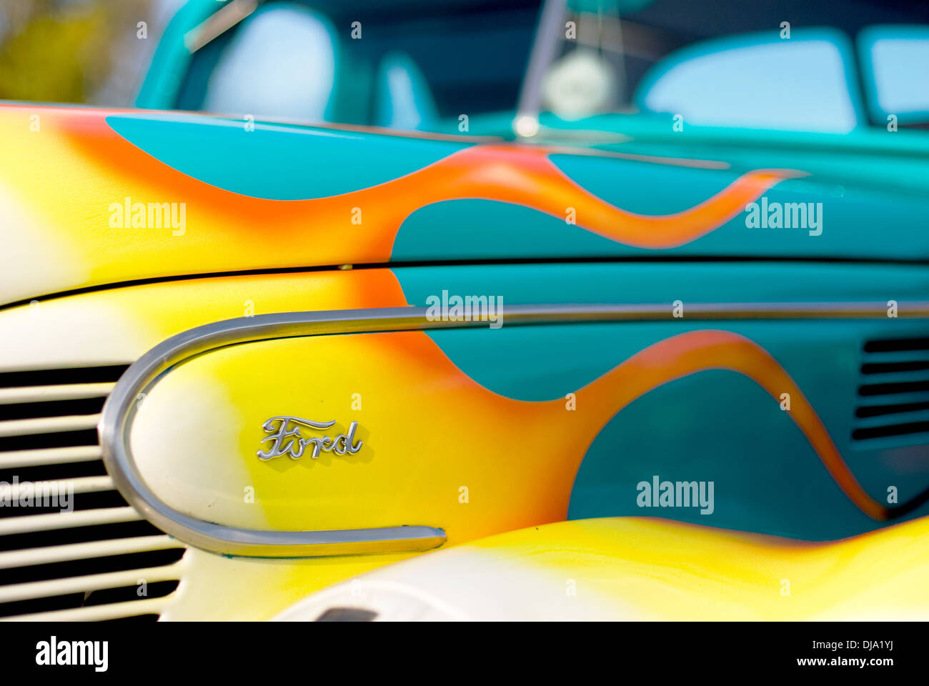 A 1939 Ford V8 hot rod painted blue with white and yellow flames on the hood, side view from front right. Stock Photo