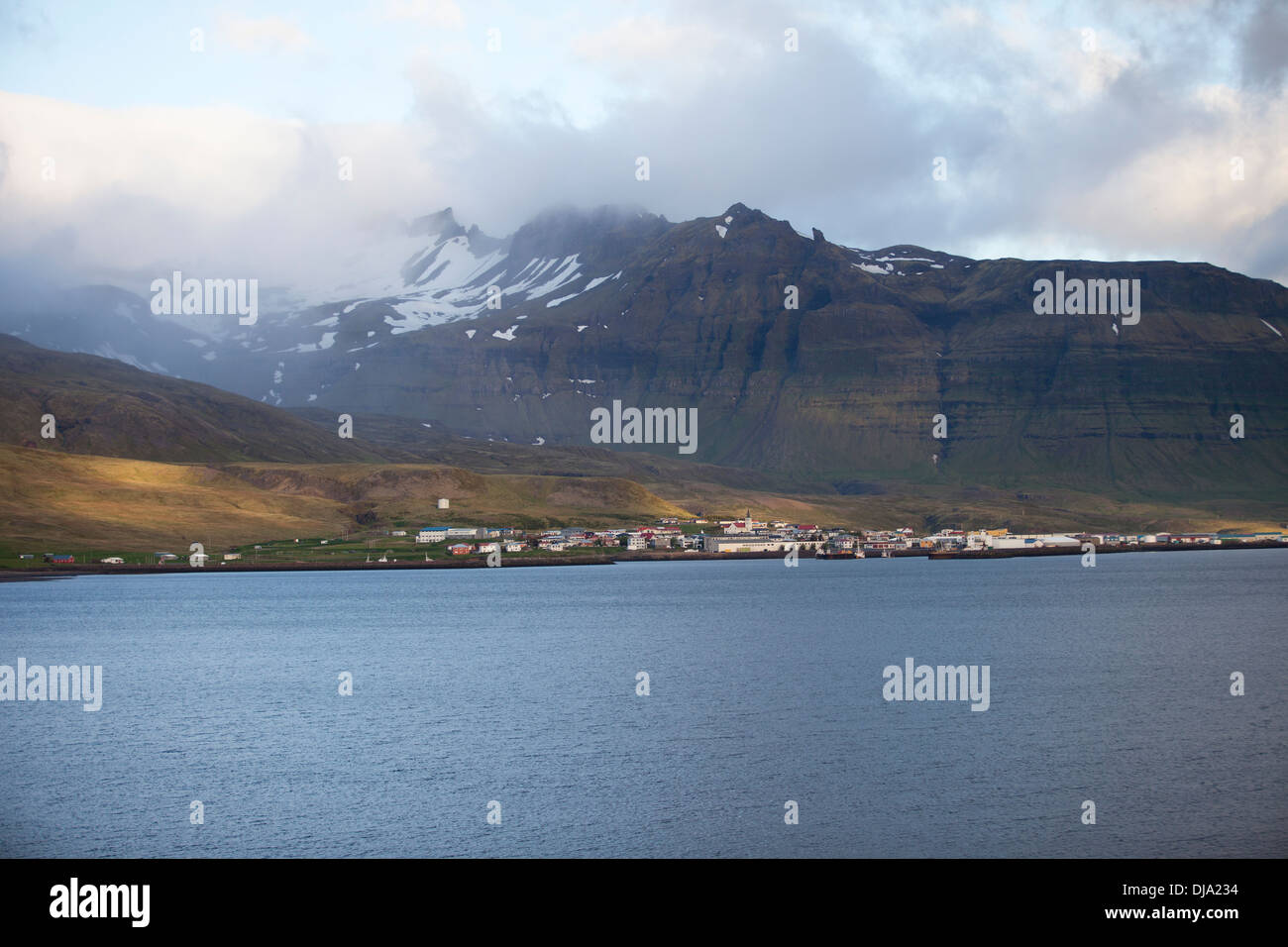 View of a large city in Iceland with cloud-covered mountain behind Stock Photo