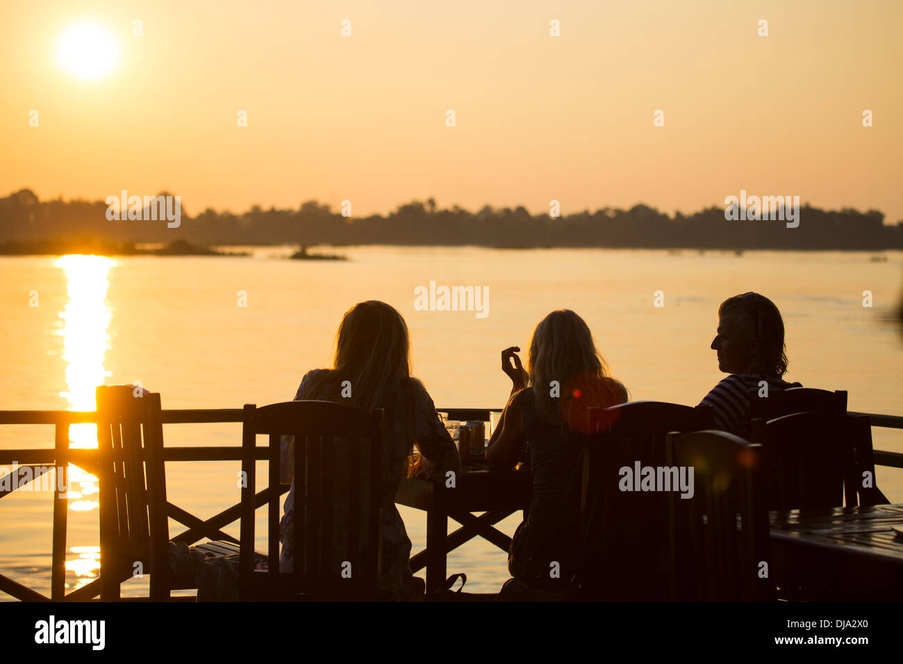 Tourists having a sundowner in Don Det island in the Mekong River, 4000 Islands in Southern Laos Stock Photo