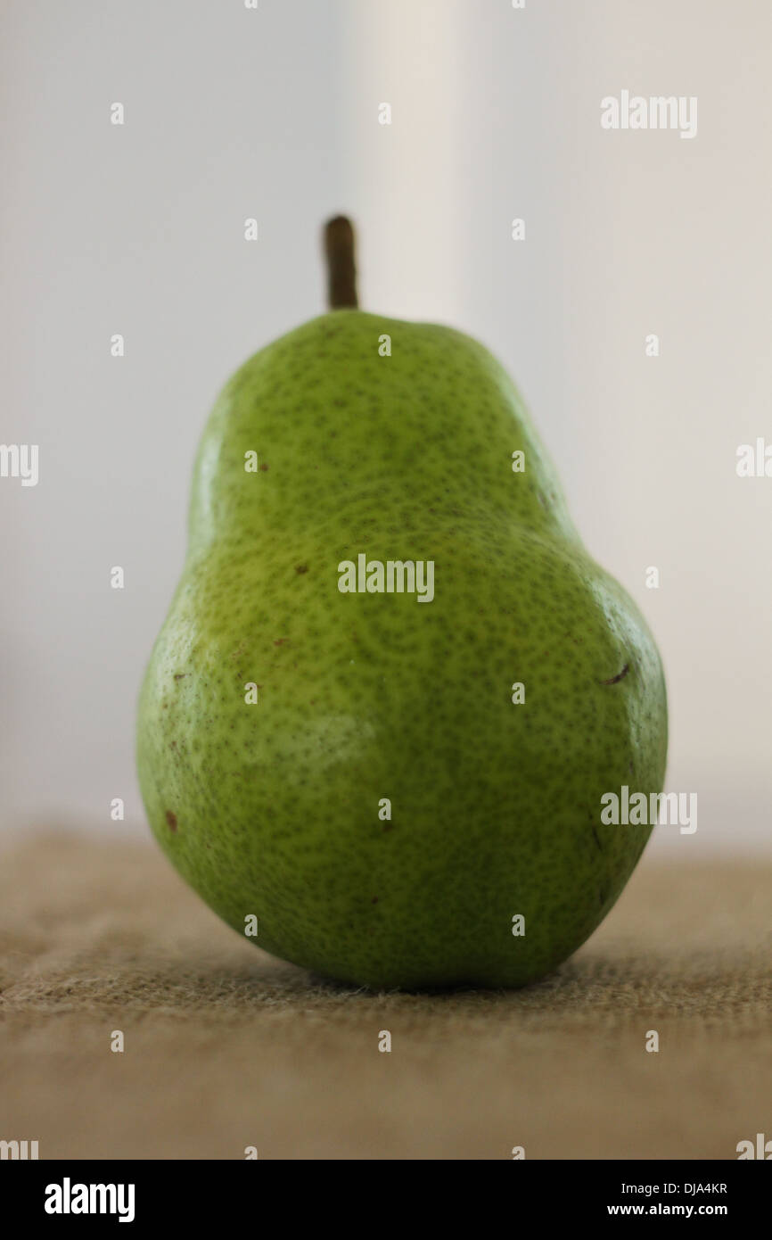 A green pear on a dinner table Stock Photo