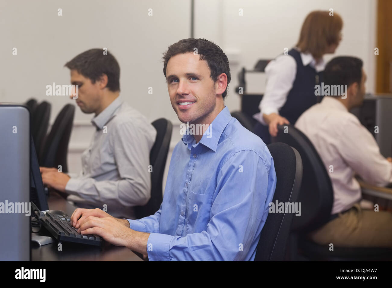 Attractive male student sitting in computer class Stock Photo - Alamy