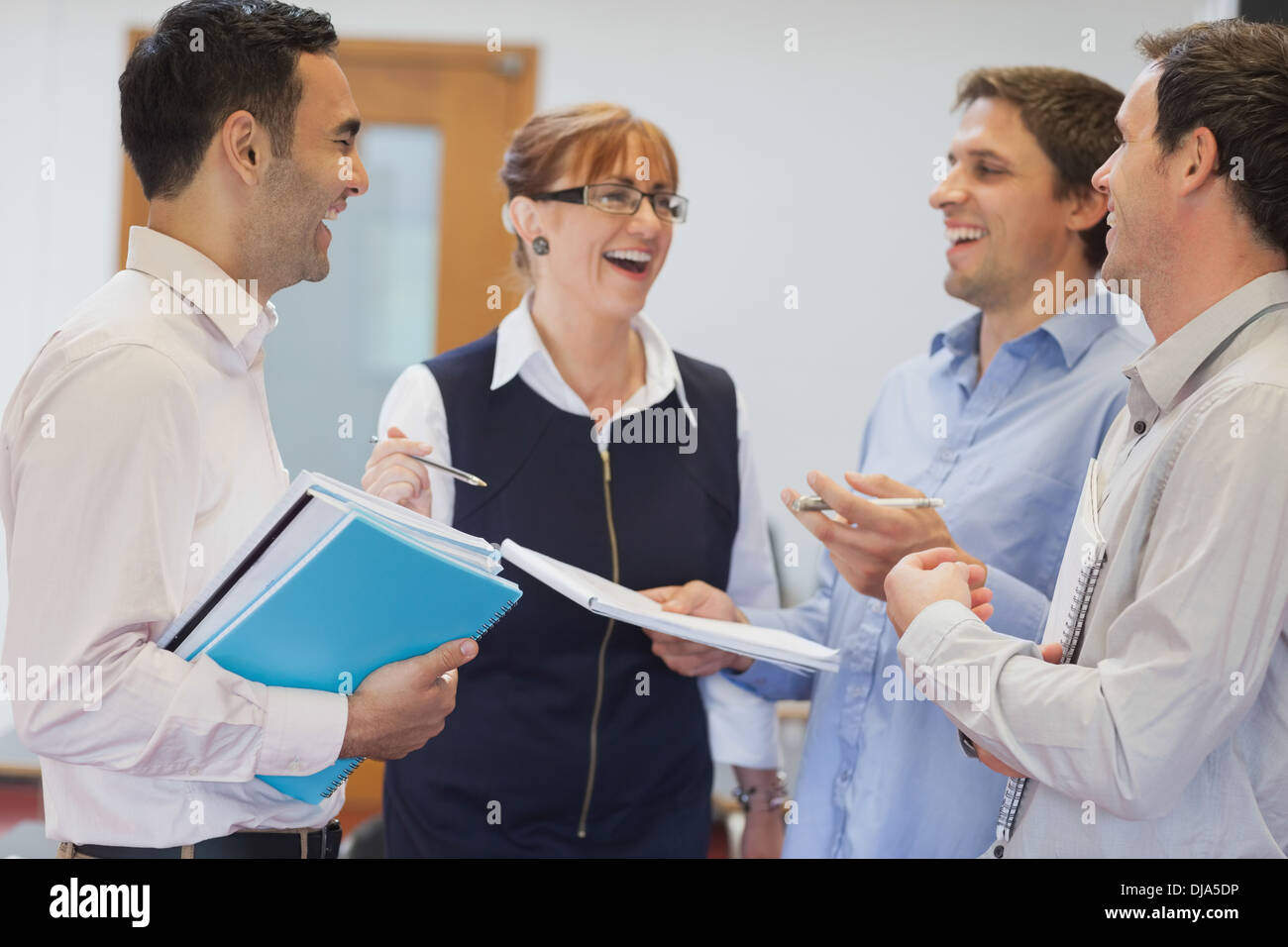 Group of mature students standing in classroom chatting Stock Photo