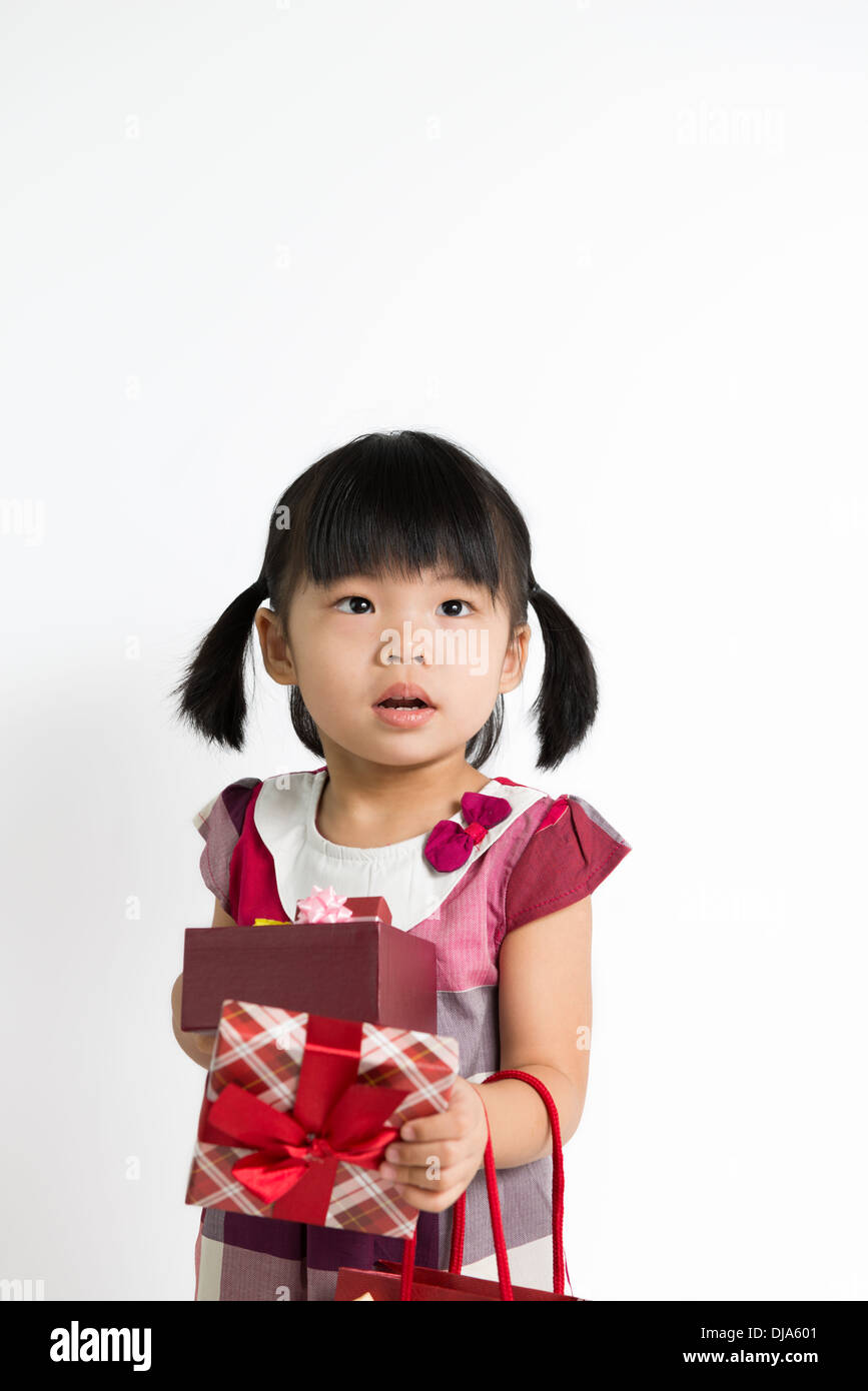 Portrait of little girl holding gift box and bag Stock Photo - Alamy