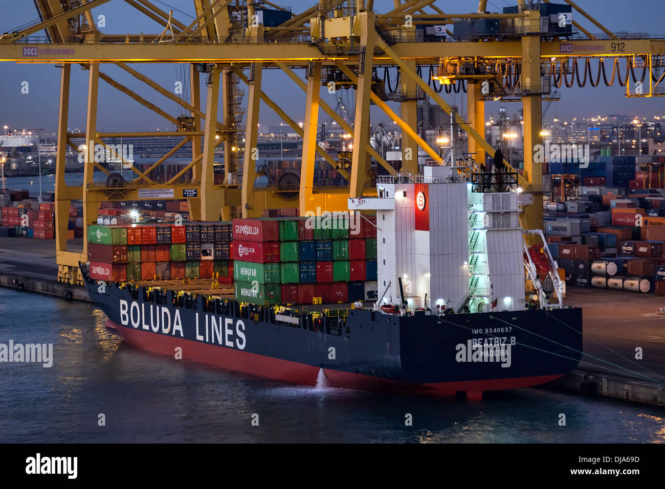 Cargo containers being loaded on to a shipping freighter , Barcelona, Spain Stock Photo