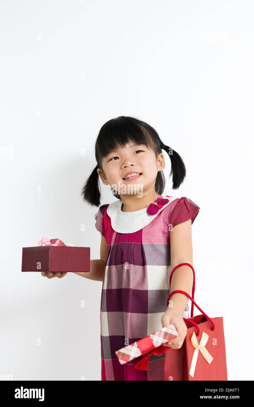 Portrait of little girl holding gift box and bag Stock Photo - Alamy