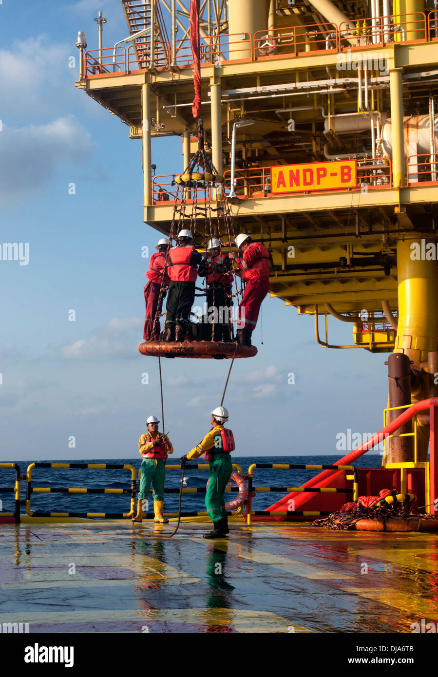 offshore worker transfer from platform to vessel by using crane bucket Stock Photo