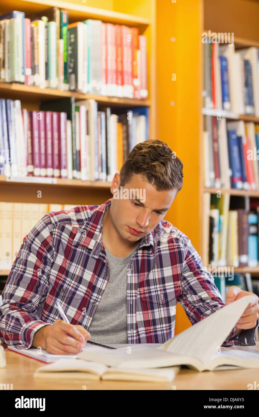Handsome focused student taking notes Stock Photo