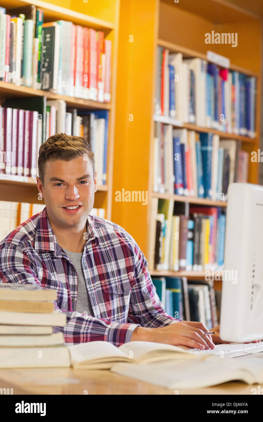 Handsome smiling student using computer Stock Photo