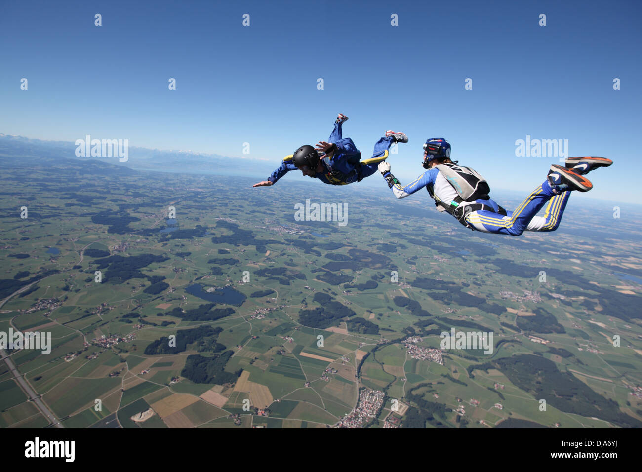 Skydivers are jumping out of an airplane and training together in the