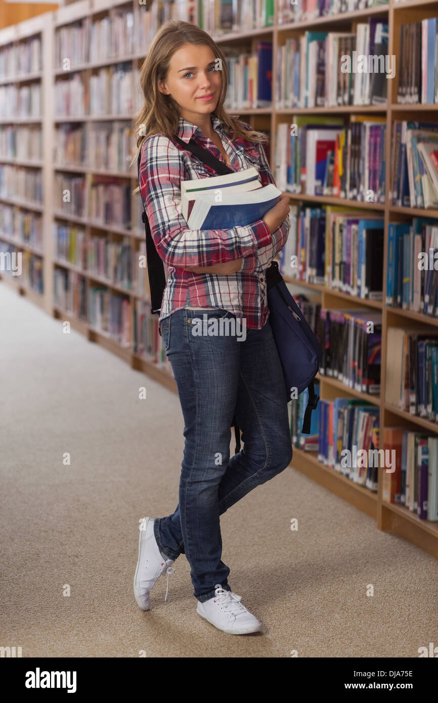 Pretty smiling student looking at camera holding books Stock Photo - Alamy