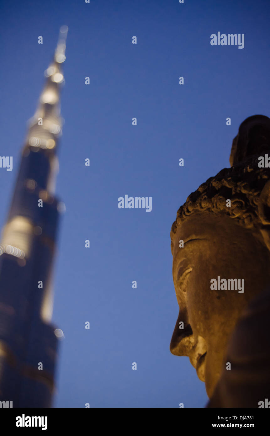 A Buddha statue with the Burj Khalifa on the background. Dubai, United Arab Emirates Stock Photo