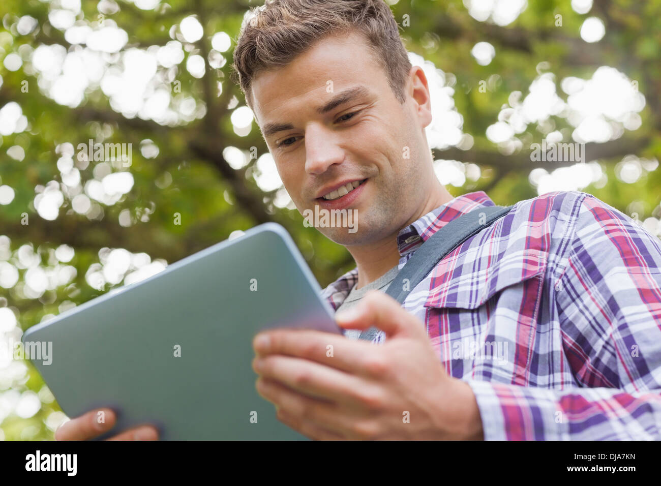 Handsome happy student using tablet Stock Photo
