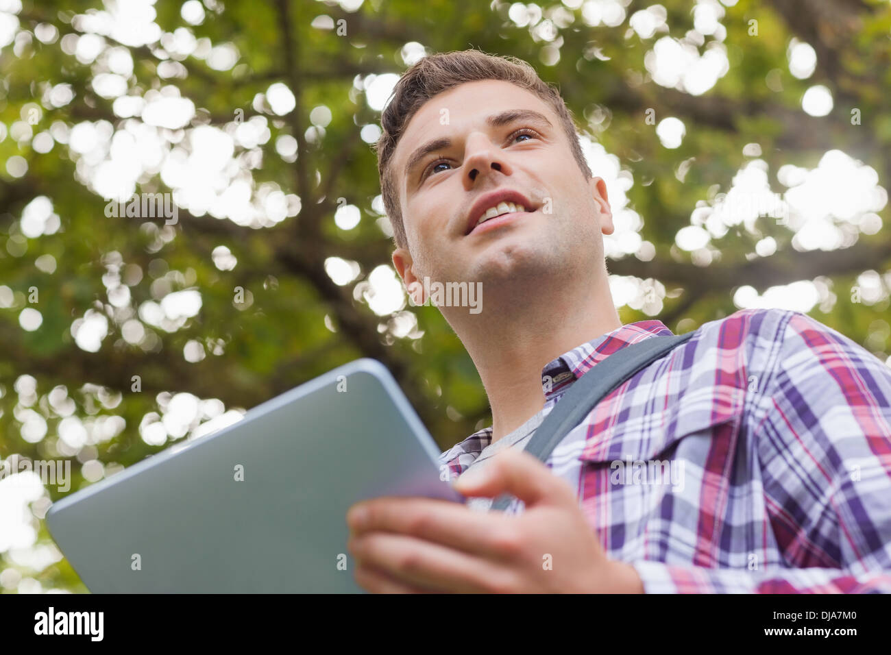 Handsome smiling student using tablet Stock Photo