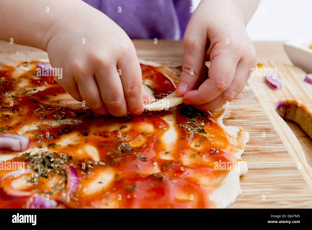 small hands preparing fresh pizza. Studio shot Stock Photo